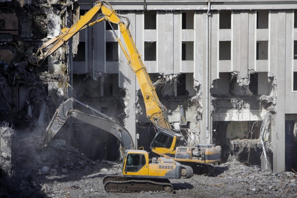 demolition for new construction, using a two special hydraulic excavator-destroyer