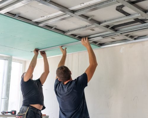 Construction worker ceiling work installation