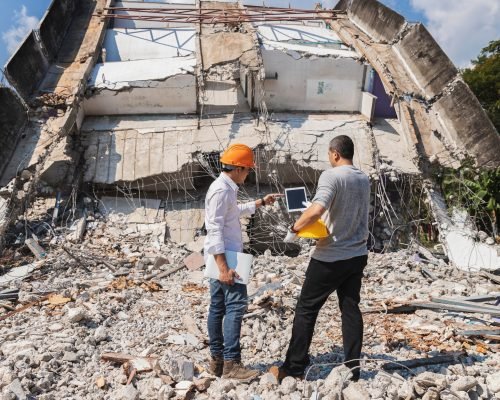 Demolition control supervisor and foreman discussing on demolish building.
